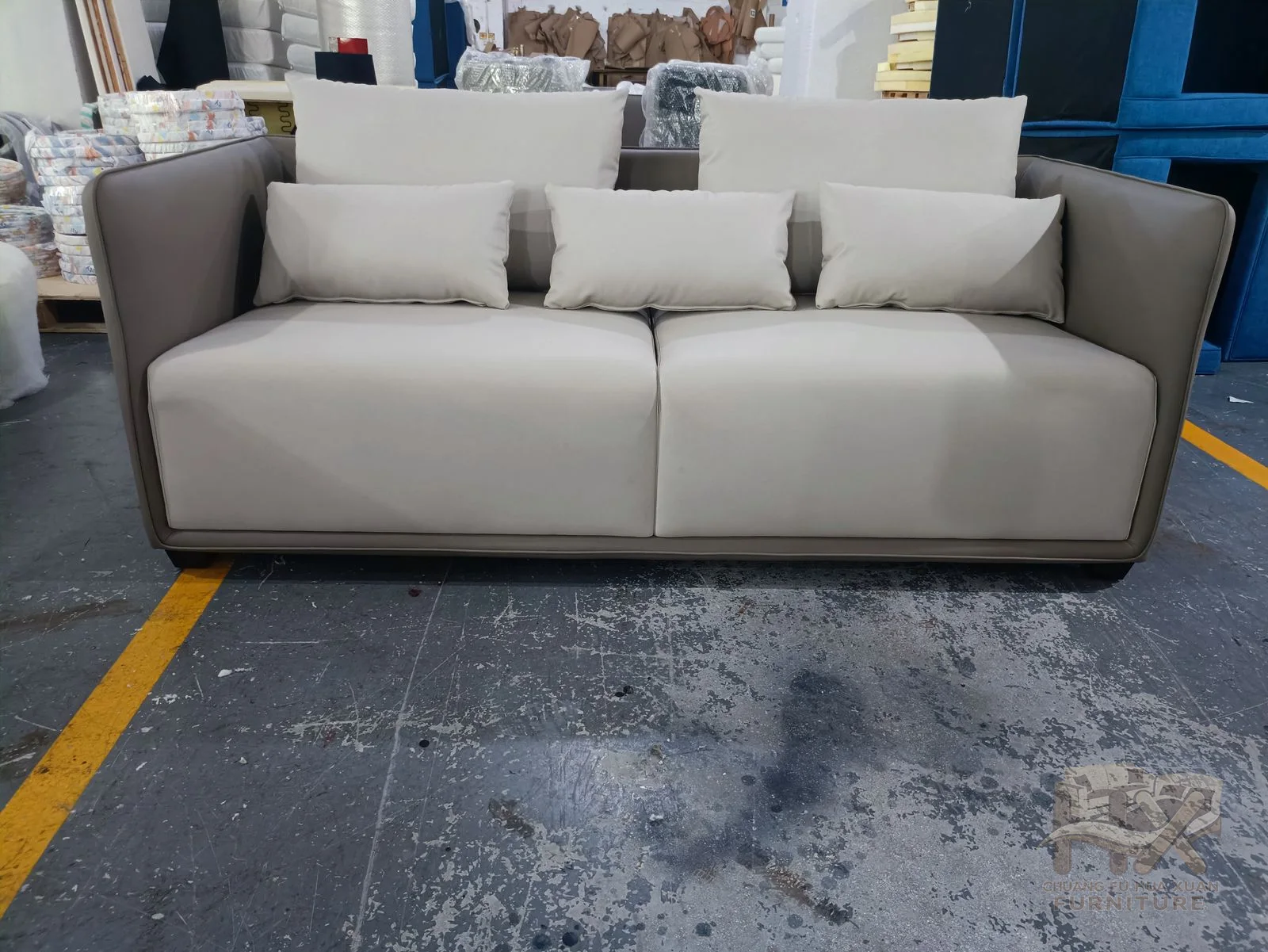 A pale sofa and matching armchair share rounded arms, deep cushions and a low upholstered base.