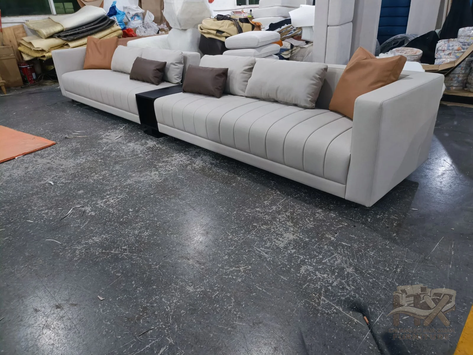 Multiple white modules create a generous inward-facing seating composition with deep cushions and square arms.