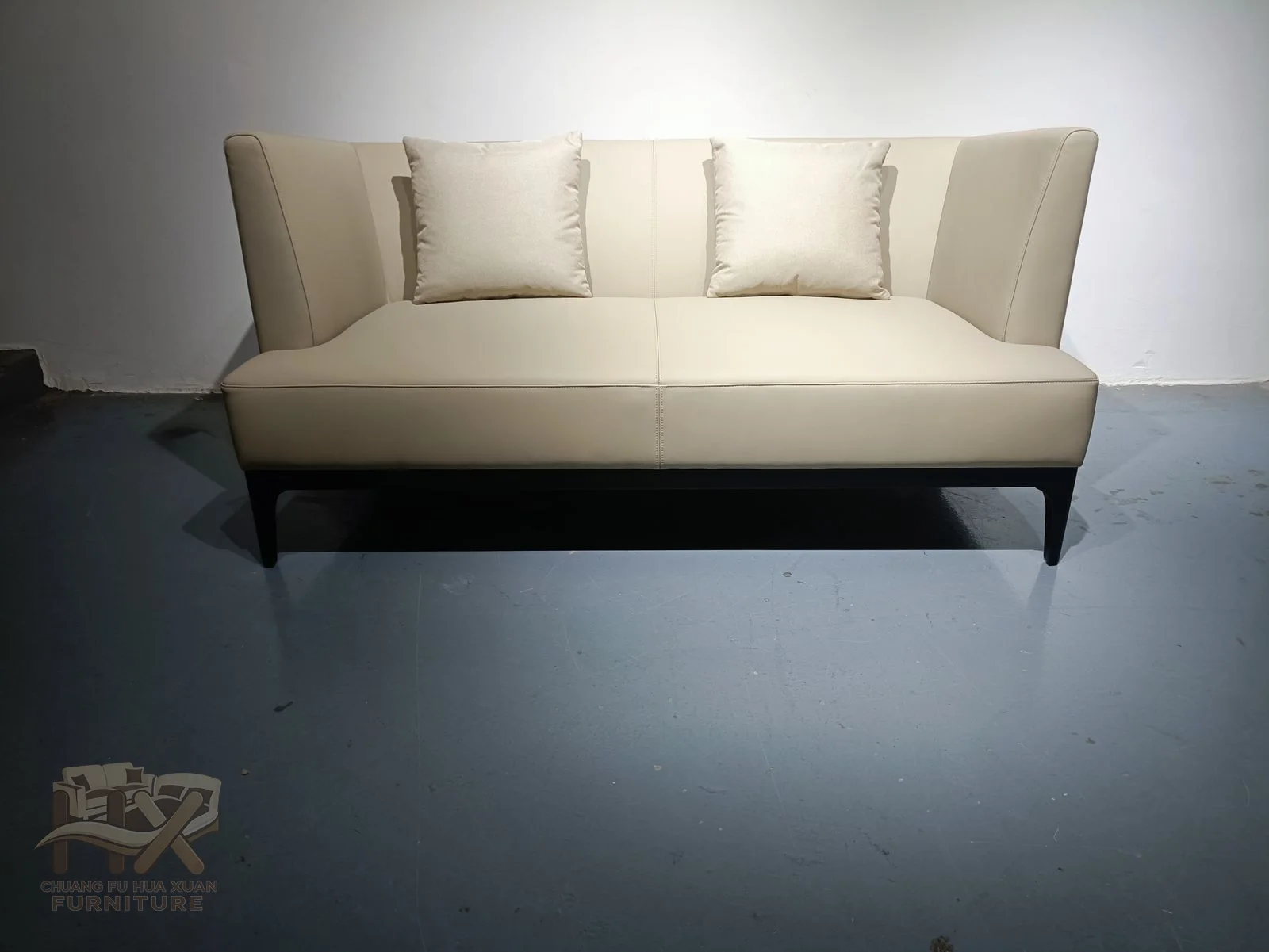 Softly flared pale arms open away from a compact two-seat centre over narrow dark feet.