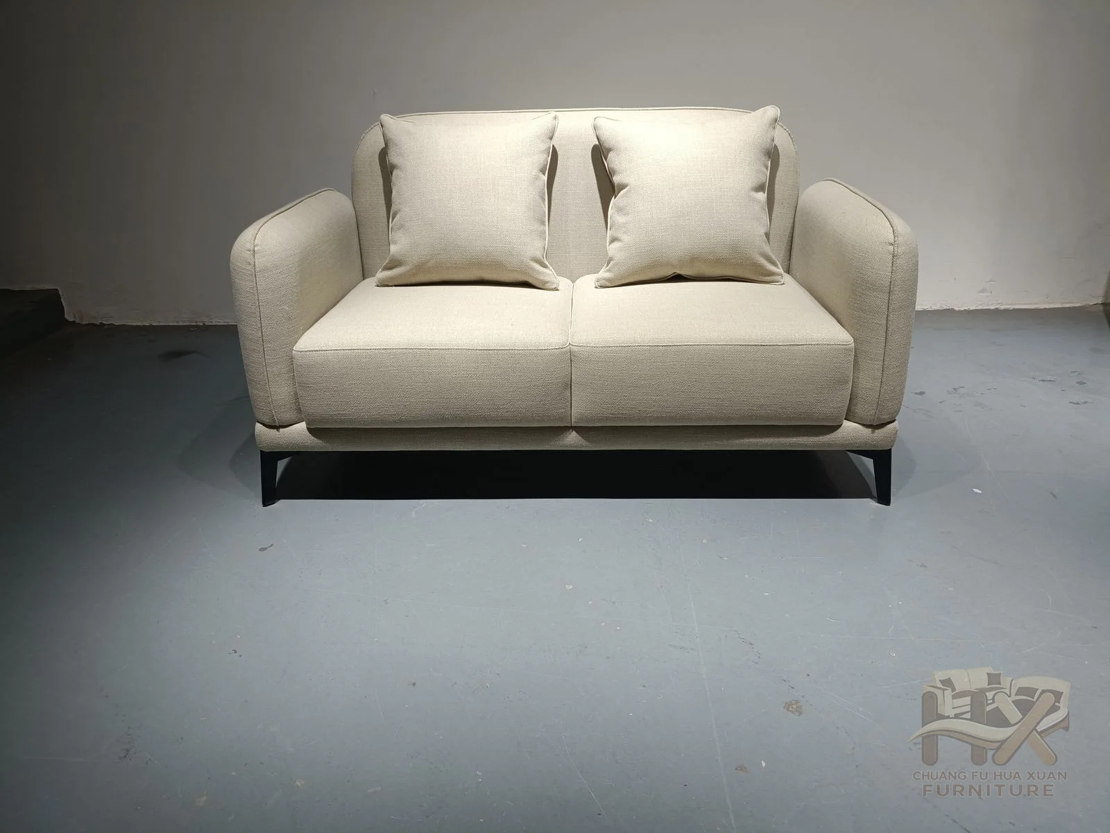 Cream sofa widths share softly rounded arms and loose pale back cushions above a low base.