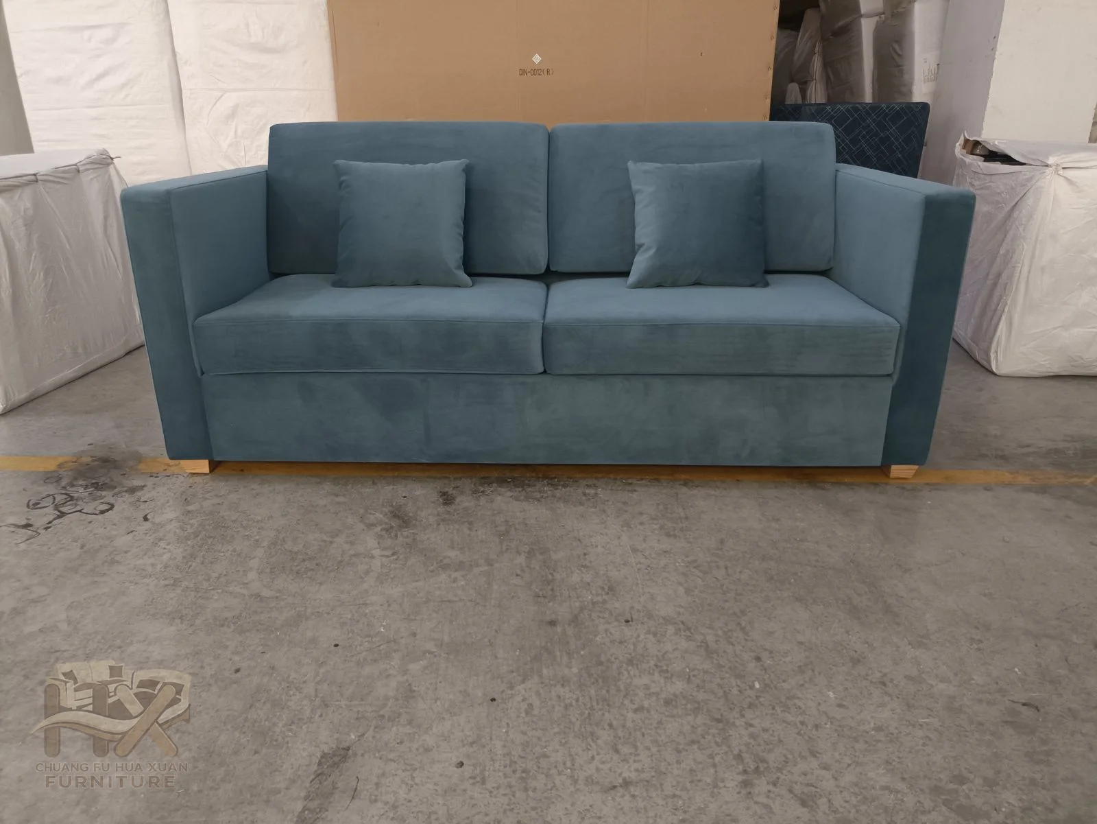 A muted blue sofa has straight level arms and long horizontal cushions over an upholstered base.