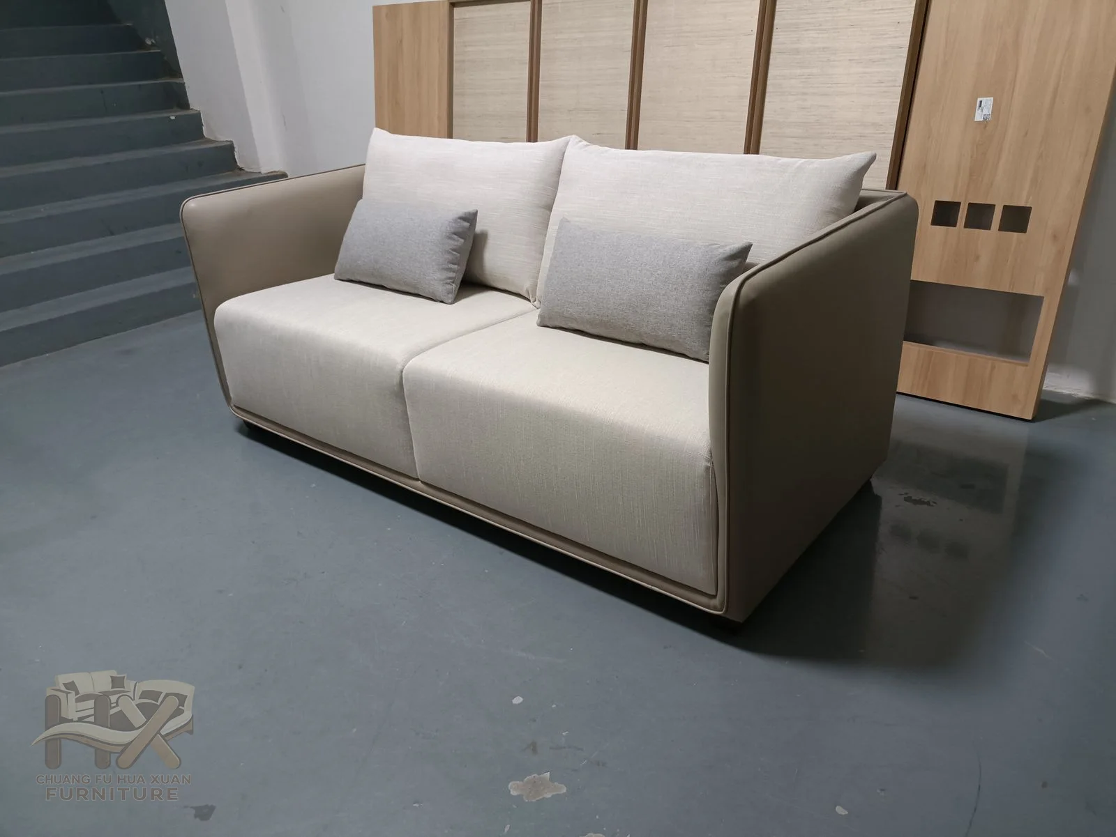 Pale seat and back cushions sit inside a darker brown straight outer frame.