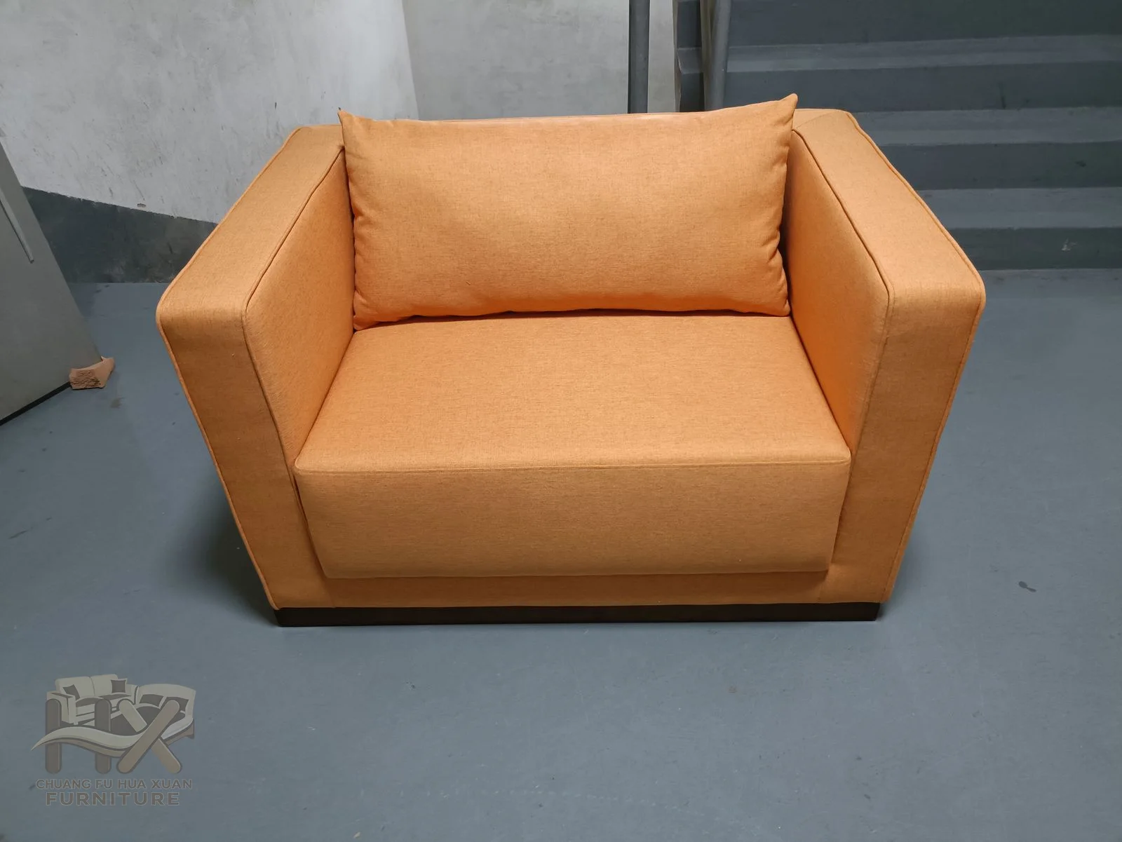 An ochre armchair and sofa share broad geometric arms and firm cushion lines.