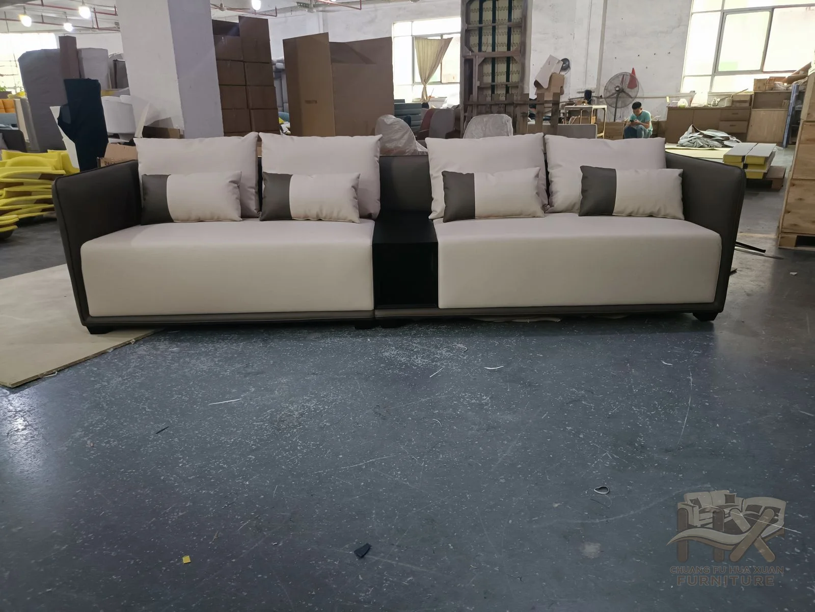 Pale upholstered modules form a broad corner with low backs and deep square seats.