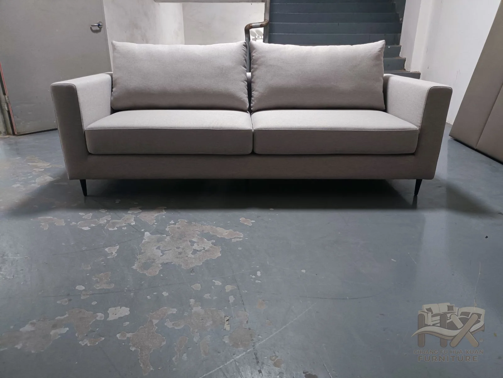 Three grey cushions sit between straight upholstered arms over a low rectangular base.