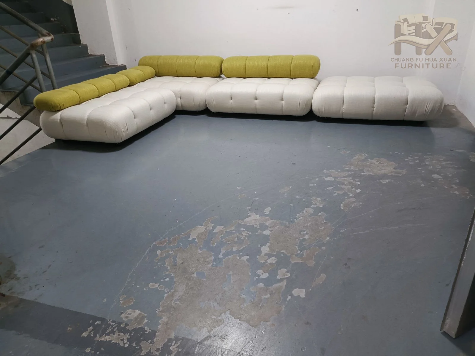 A long curved sectional alternates warm yellow and pale upholstery along its rounded seat run.