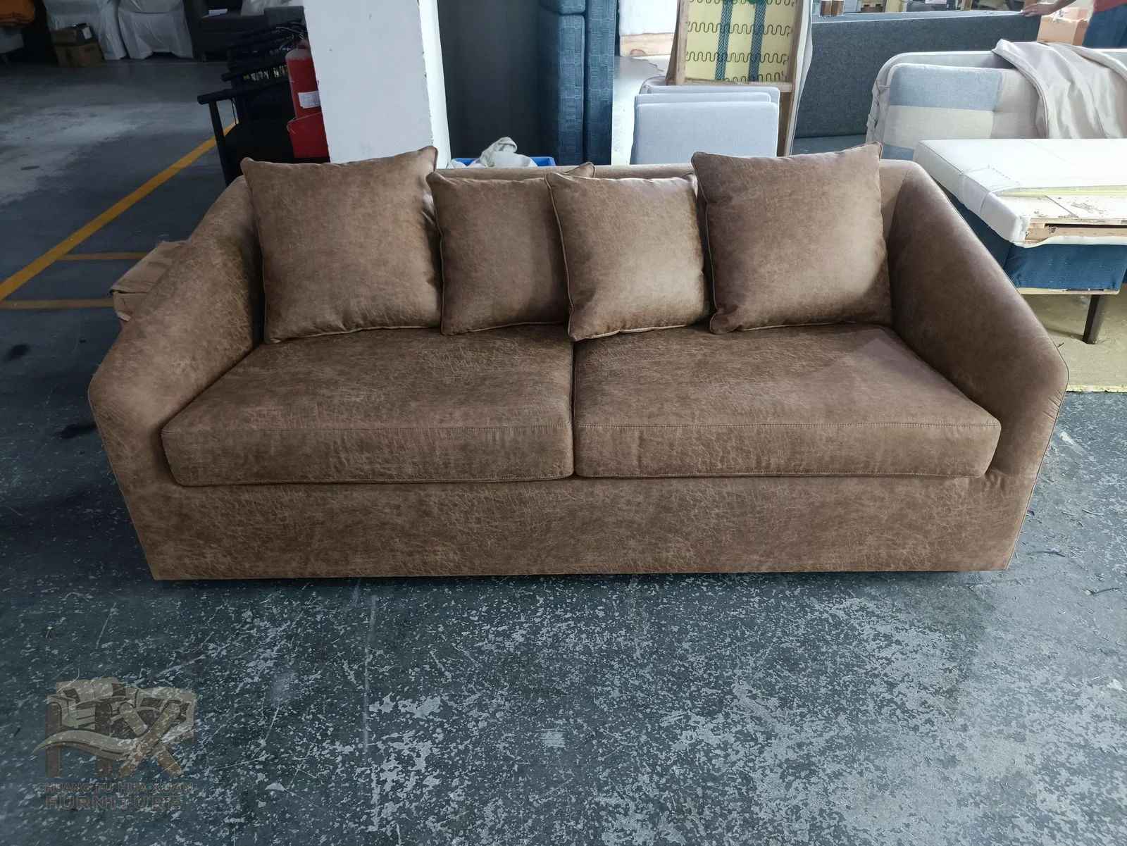 A brown three-seat sofa sits low with cushioned backs and short broad arms.