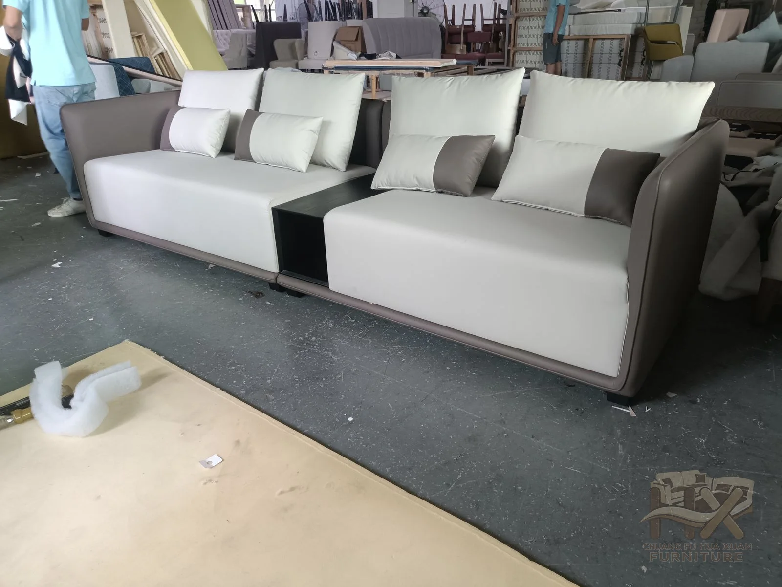 Pale seat and back cushions sit inside a darker outer arm and base shell.