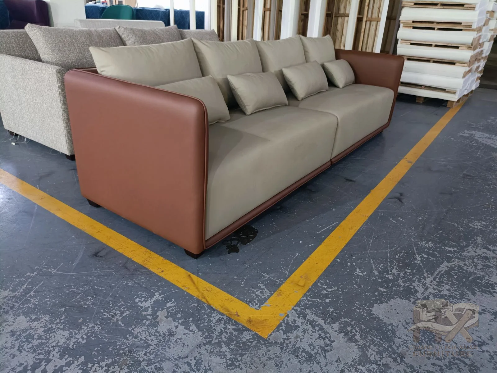 A pale sofa places loose cushions between rust-coloured outer arm panels.