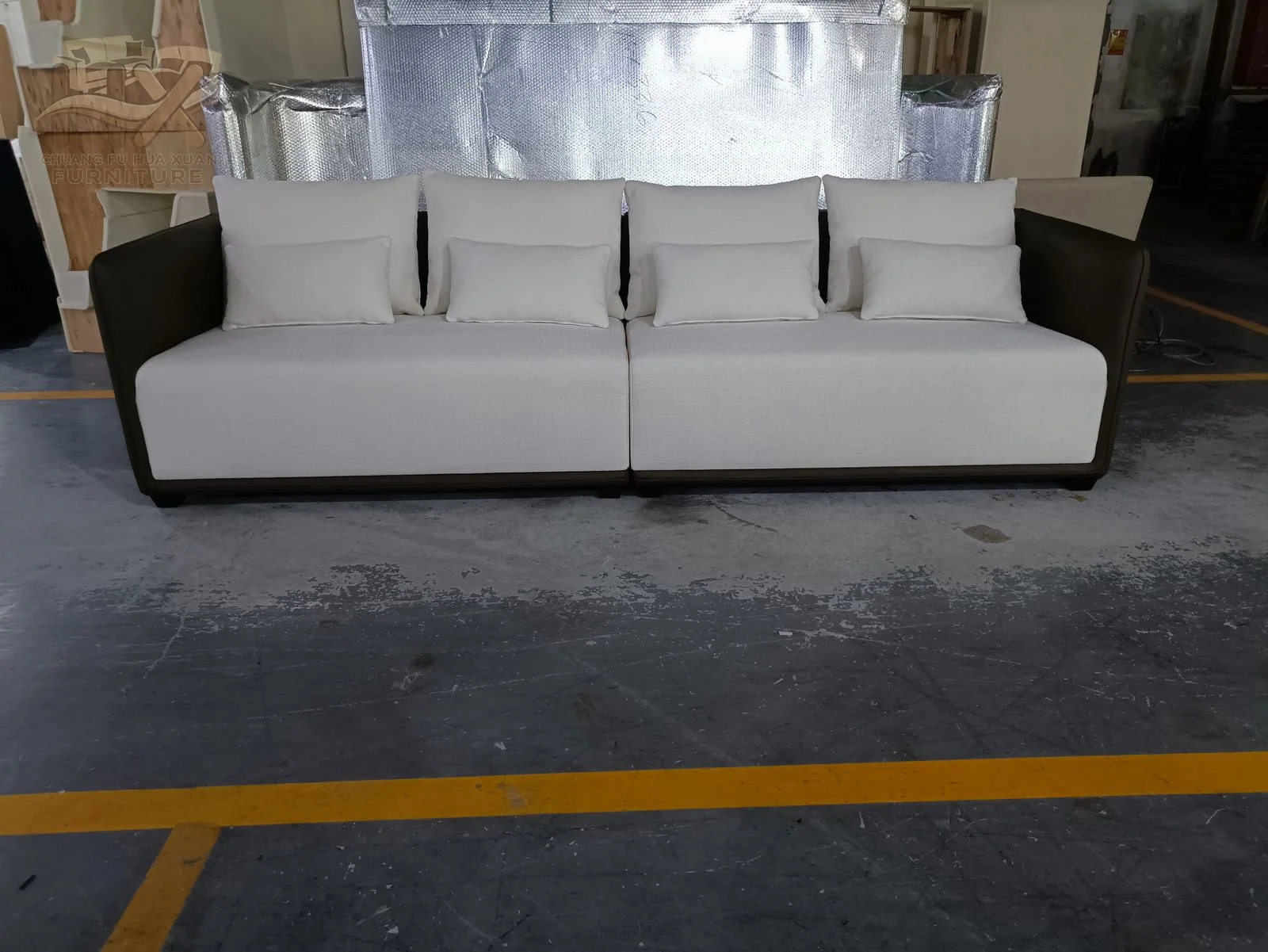 White cushions sit inside a dark outer arm and base shell on a straight sofa.