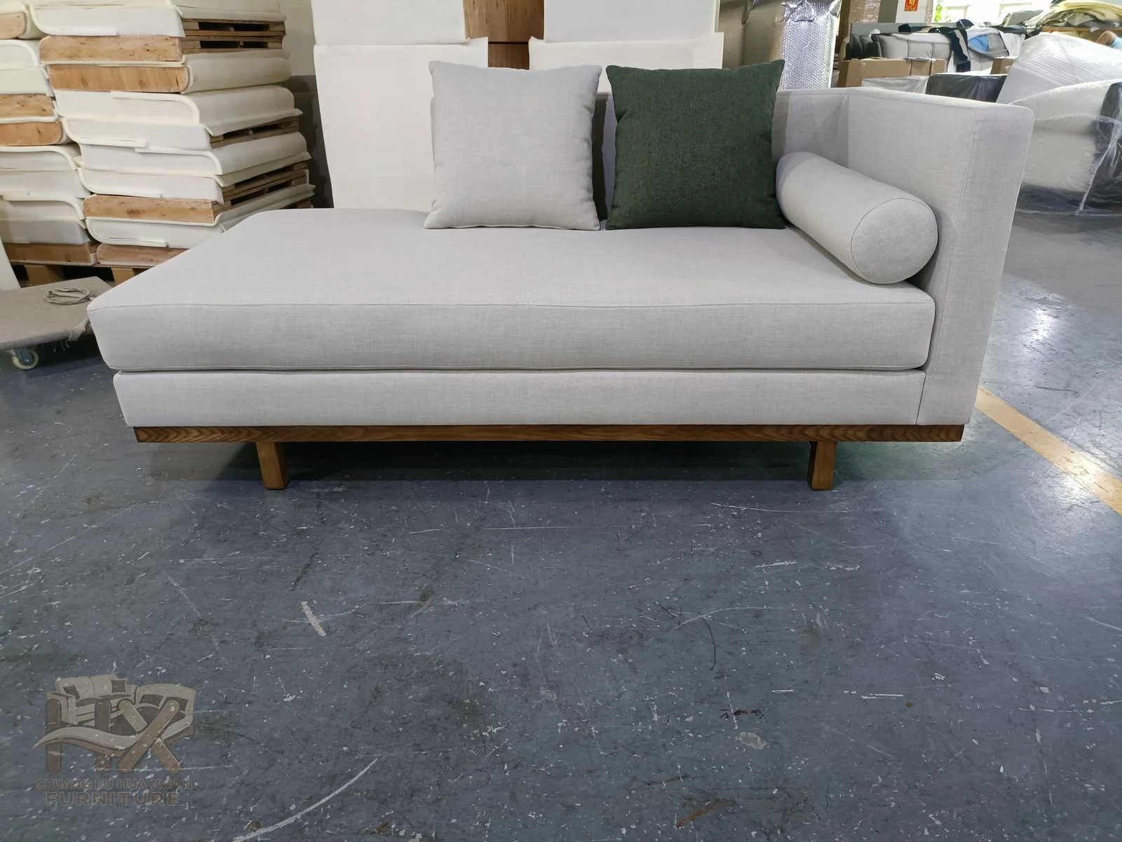 A white sofa extends one seat into a long reclining chaise beside its straight cushion run.
