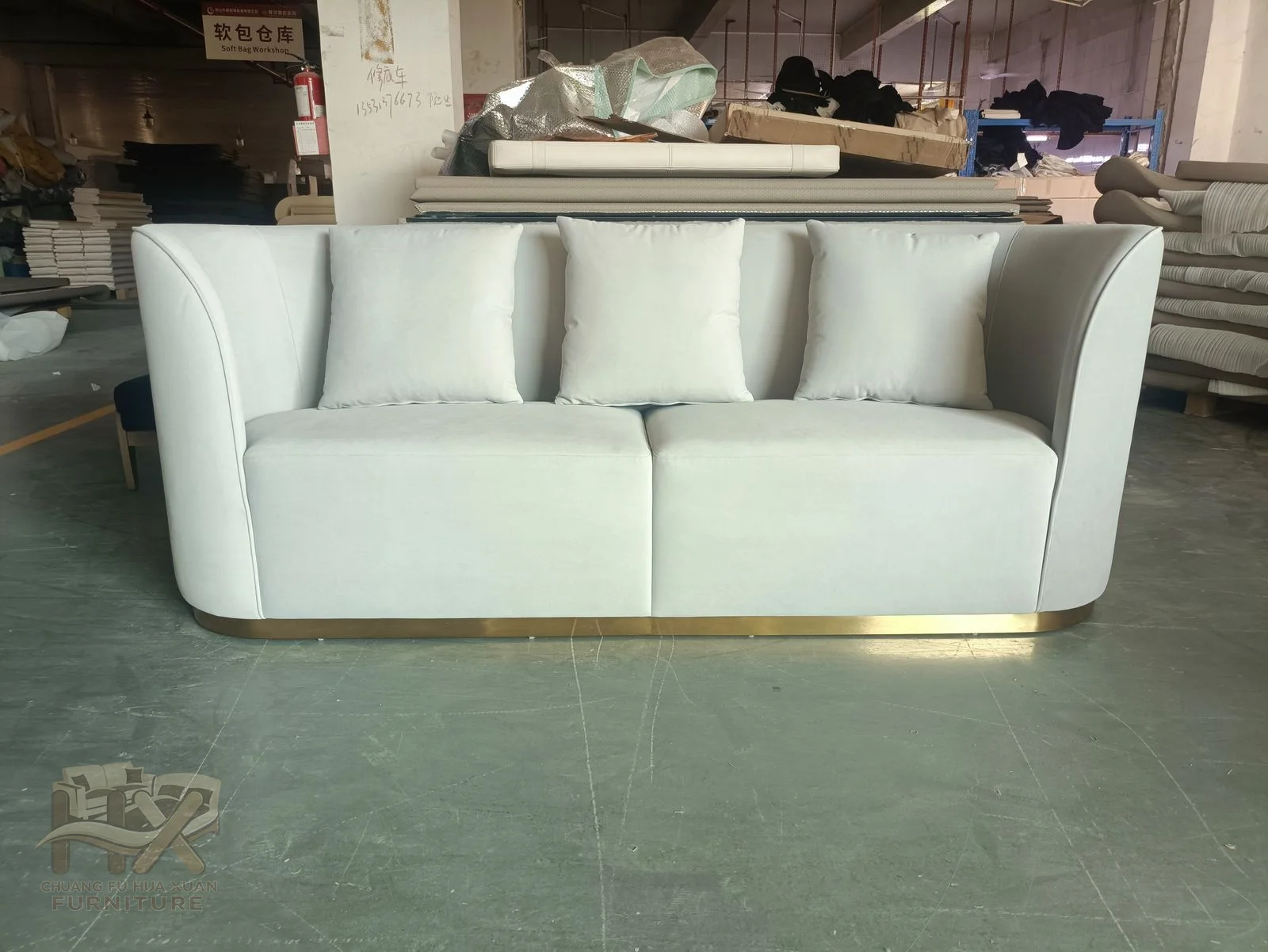 A compact white sofa rounds its short arms around two deep seats and a low cushioned back.