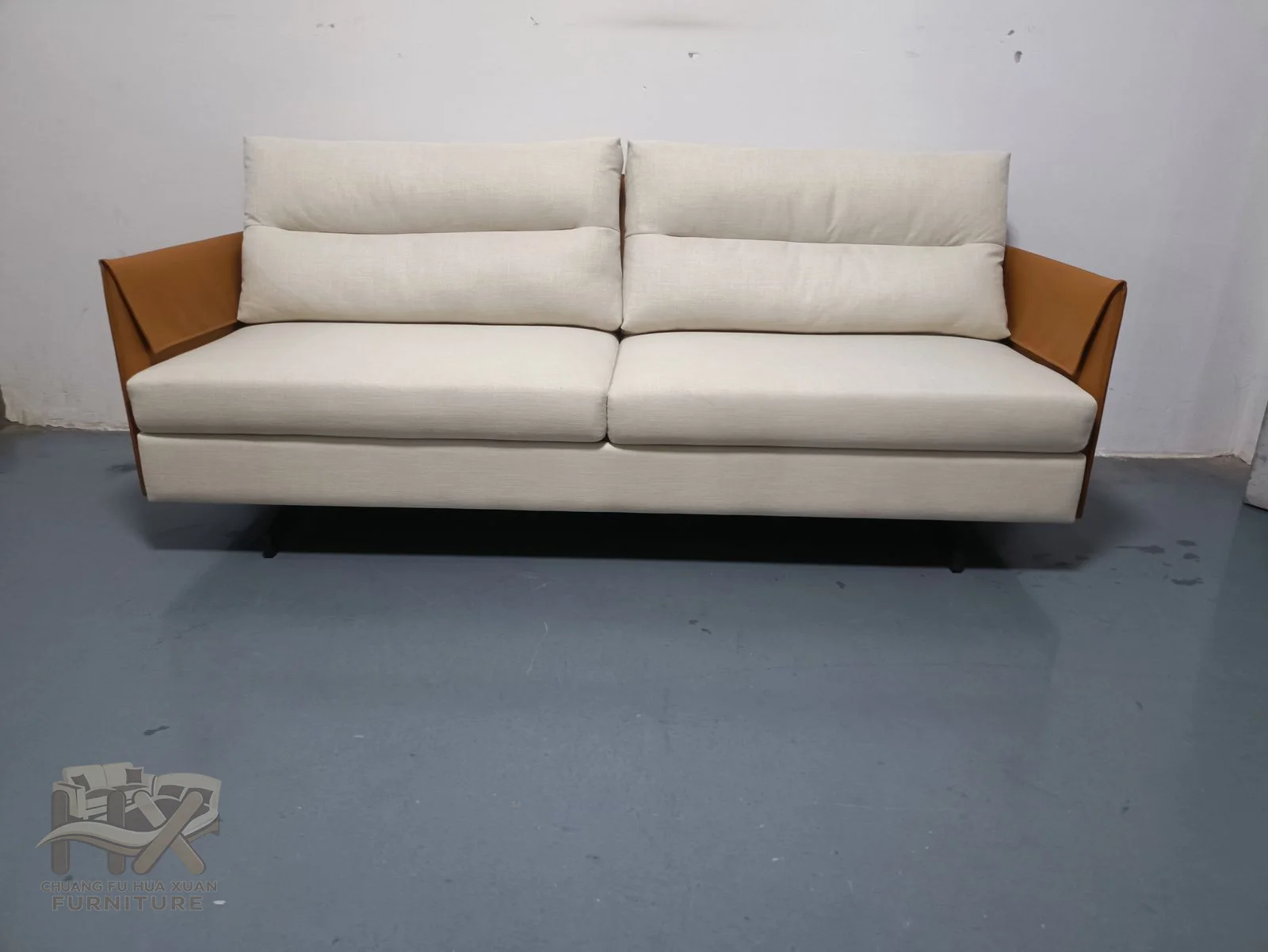 Pale cushions sit above a slim base with tan outer arm panels.