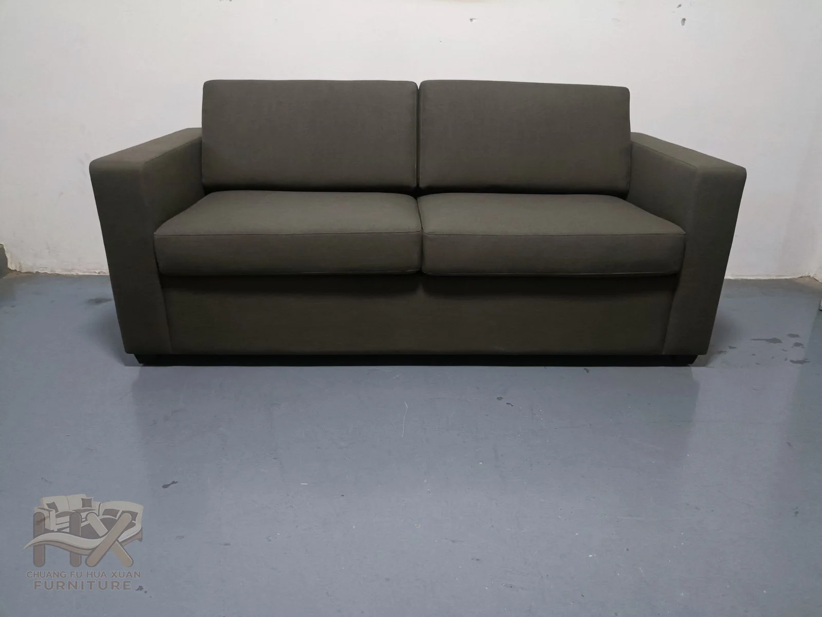 A charcoal compact sofa uses straight padded arms and a continuous low back.