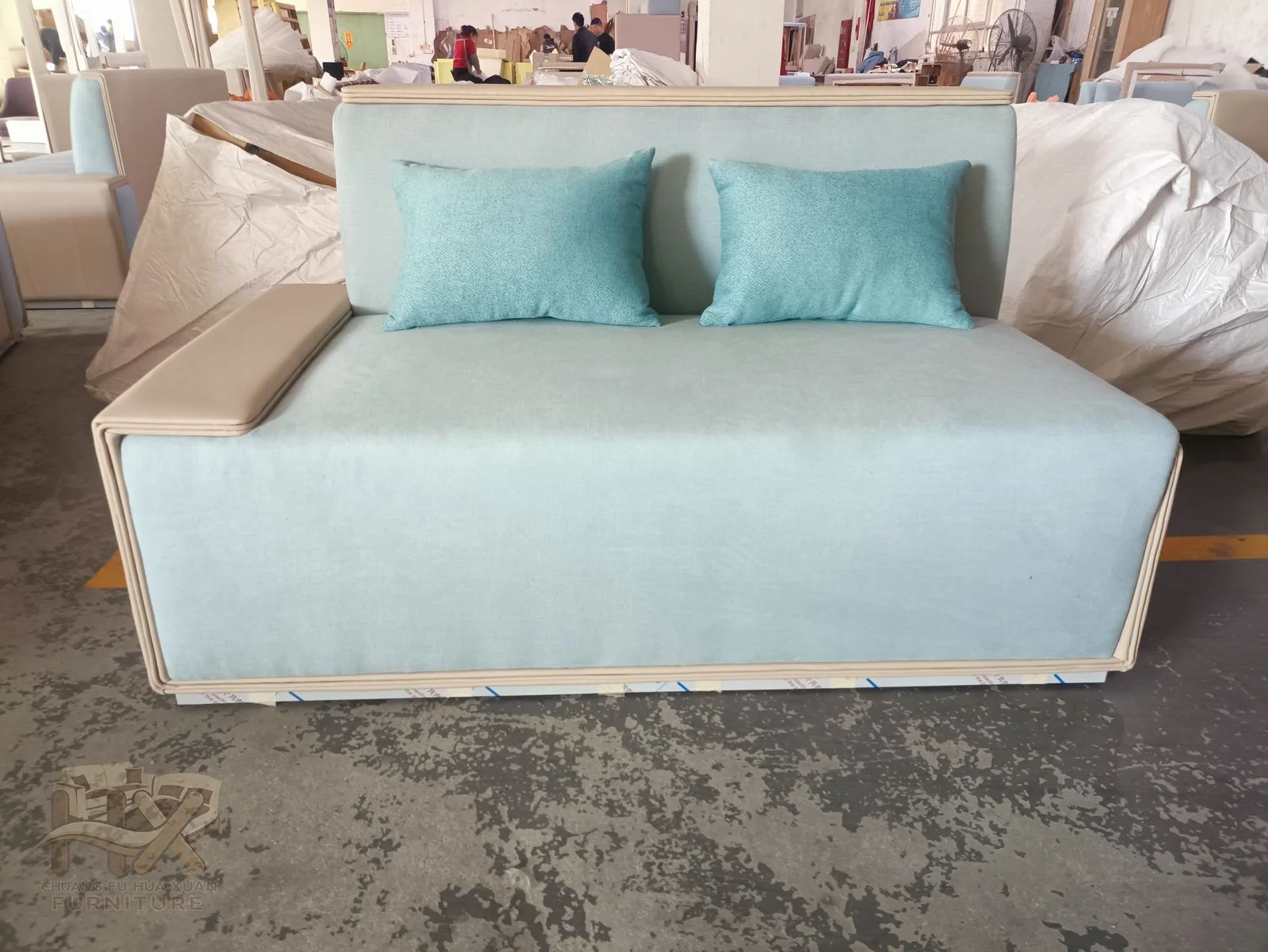 A pale blue compact sofa has low straight arms and two cushioned seats.