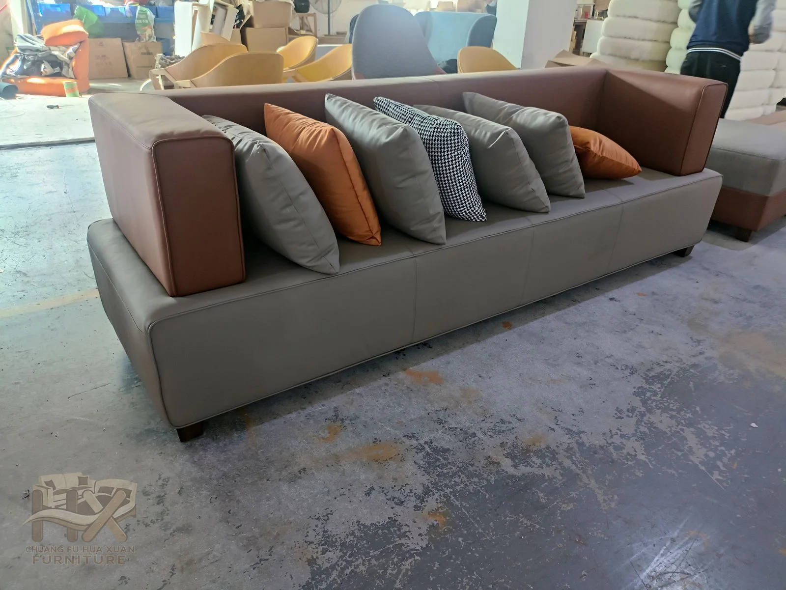 A charcoal sofa pairs a deep seat with mixed warm and cool loose cushions.