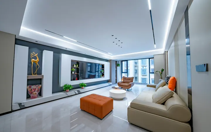 Contemporary living room with a cream sofa, orange ottoman and lounge chair