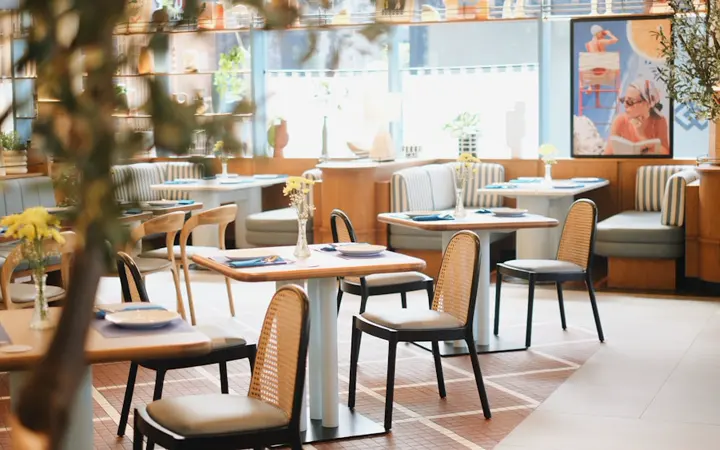 Restaurant dining layout with upholstered chairs, tables and banquette seating