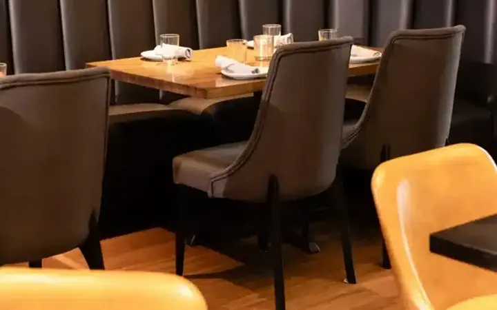Brown upholstered dining chairs arranged beside restaurant tables