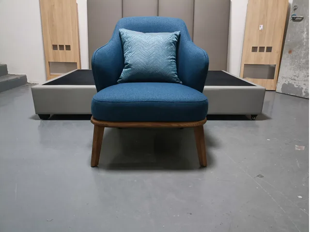 Blue upholstered lounge chair shown front-on in the workshop