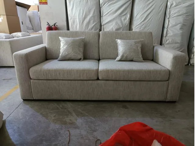 Light grey upholstered sofa bed shown in sofa mode in the workshop