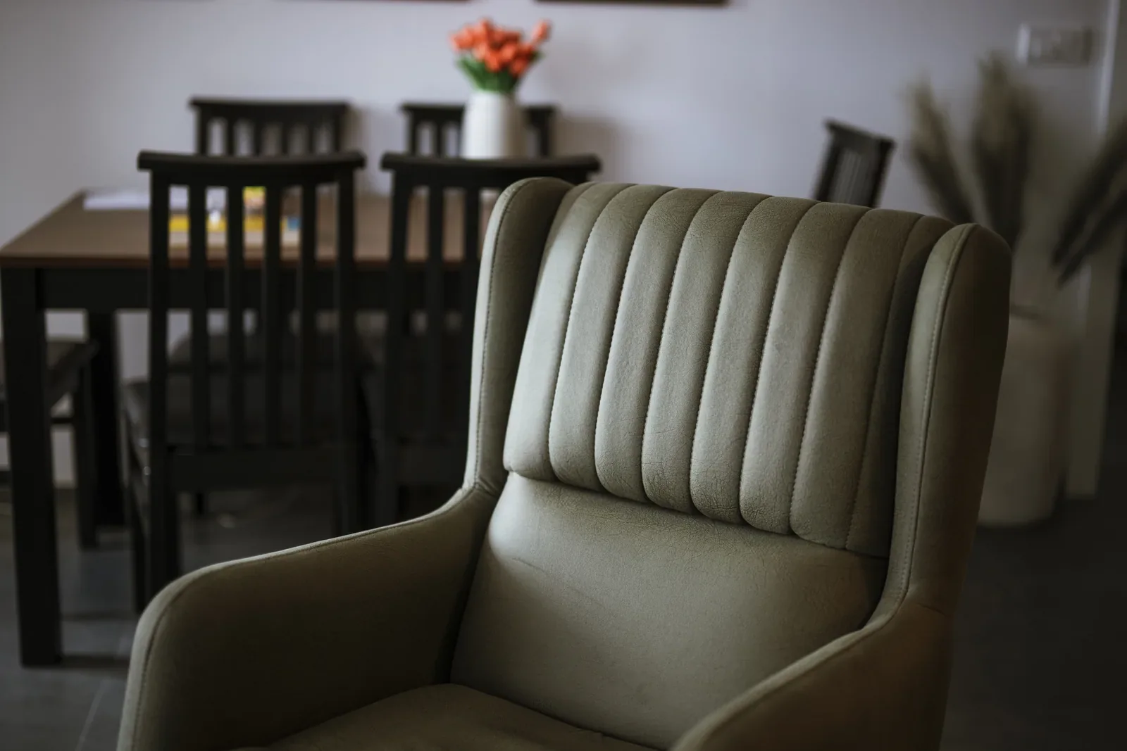 Curved upholstered dining chair beside a dining table in natural light